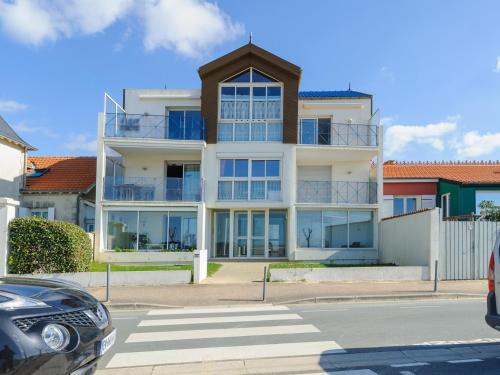 - un grand bâtiment blanc avec des fenêtres en verre dans l'établissement Appartement T2 à 50m de la Plage, Balcon, Wifi, Tout Confort, 4 Pers, Châtelaillon-Plage - FR-1-535-9, à Châtelaillon-Plage
