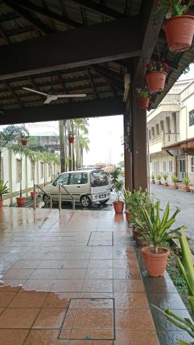 a car parked in a parking lot with potted plants at Luxury property 2024 new in Gua Sai