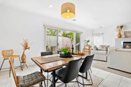 a living room with a wooden table and chairs at Salty Sage Beach House in Torquay