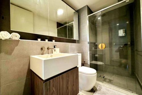 uma casa de banho com um lavatório, um WC e um chuveiro em City Chic Living: 1-BR APT Overlooking Rundle Mall em Adelaide