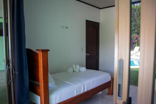 a bedroom with a bed with white sheets and a window at Home La Fortuna in Fortuna