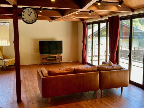 a living room with a couch and a clock on the wall at 極楽寺邸 - Gokurakuji House in Kamakura