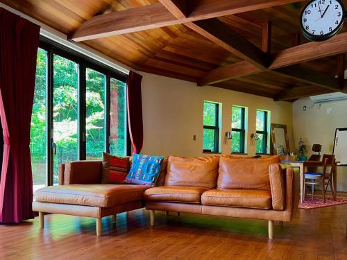 a living room with a couch and a clock on the wall at 極楽寺邸 - Gokurakuji House in Kamakura
