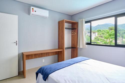 a bedroom with a bed and a window at Villa da Serra 2 - Casa com piscinas privativas vidro in Paraty
