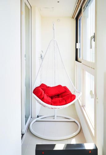 a red swing in a room with a window at The November Stay In landmark in Incheon