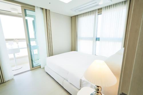 a bedroom with a white bed and a large window at The November Stay In landmark in Incheon