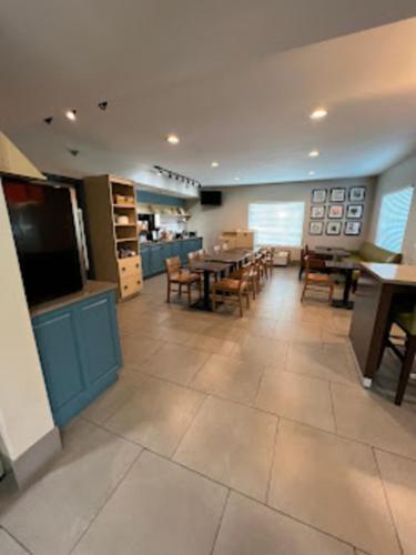 a dining room with tables and chairs and a television at Radiant Inn and Suites in Murfreesboro