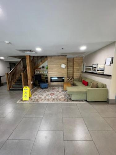 a large living room with a couch and a staircase at Radiant Inn and Suites in Murfreesboro