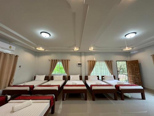 a room with several beds in it with windows at Brown Andaman Krabi in Krabi