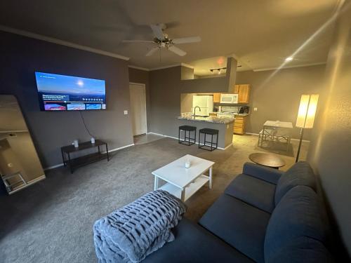 a living room with a couch and a tv at Cozy Condo in Gated Community with Pool by PHX Airport, Tempe, and Old Town in Phoenix