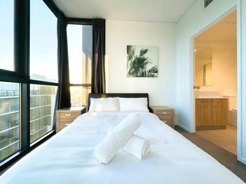 ein Schlafzimmer mit einem großen weißen Bett mit weißen Kissen in der Unterkunft High-Rise Heaven - West Franklin in Adelaide