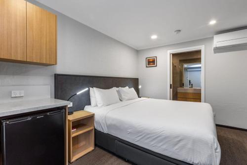 a bedroom with a large bed and a kitchen at Apollo Bay Motel & Apartments, BW Signature Collection in Apollo Bay
