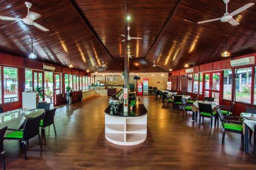 a dining room with tables and chairs in a building at Sylvia Hotel & Resort Komodo in Labuan Bajo