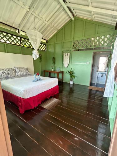 - une chambre avec un lit dans une pièce verte dans l'établissement Apsara & Dragon’s Supra Wellness Resort, à Baan Tai