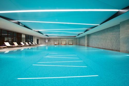 an empty swimming pool with blue ceilings and chairs at Crowne Plaza Hangzhou Science City, an IHG Hotel in Hangzhou