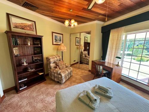a living room with a bed and a chair at Oasis of Hope - Main House in Upper Orara