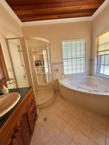 a bathroom with a large tub and a sink at Oasis of Hope - Main House in Upper Orara
