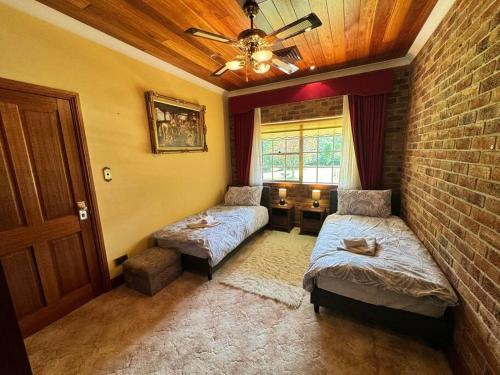 a living room with two beds and a ceiling fan at Oasis of Hope - Main House in Upper Orara