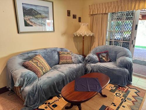 a living room with a couch and a table at Oasis of Hope - Main House in Upper Orara