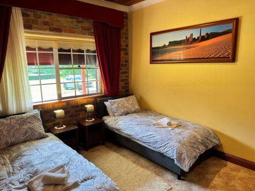 a bedroom with two beds and a window at Oasis of Hope - Main House in Upper Orara