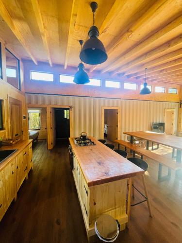 a kitchen with a large wooden table in a cabin at Pucura Eco Lodge in Licán Ray