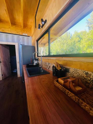 a living room with a couch and a large window at Pucura Eco Lodge in Licán Ray