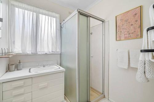 een witte badkamer met douche en wastafel bij George's at Rye in Rye