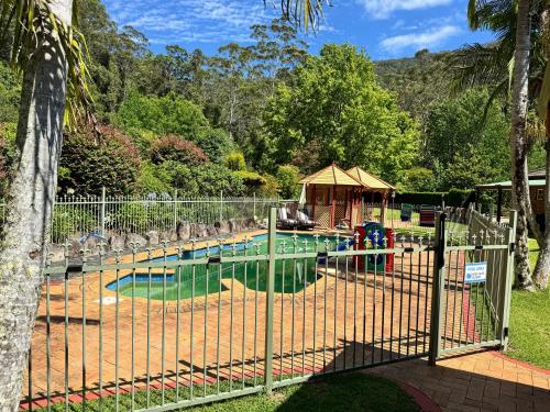a fence around a pool in a park at Oasis of Hope - Main House in Upper Orara