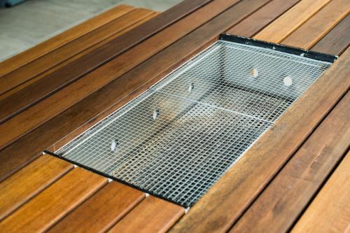 a metal grate in the middle of a wooden floor at Monterey House by SANA in Tateyama