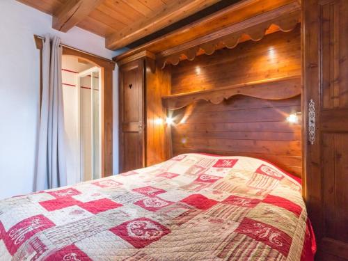 a bed in a room with a wooden wall at Appartement Les Arcs 1800, 3 pièces, 6 personnes - FR-1-346-348 in Arc 1800