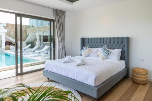 a bedroom with a large bed and a swimming pool at Luxury 5 bedroom oceanview villa in Bophut with Staff in Amphoe Koh Samui