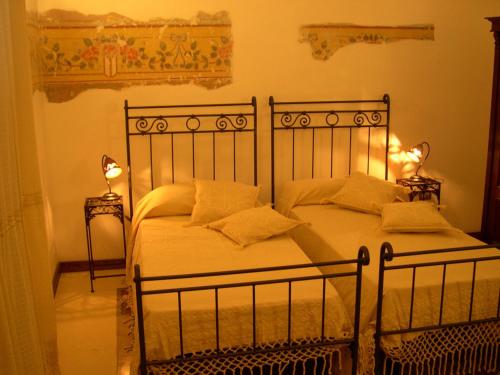 a bedroom with two beds and two lamps on tables at Li Traìni in San Pietro in Lama