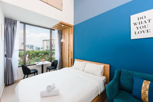 een slaapkamer met een bed en een blauwe muur bij S'Home Saigon - Infinity Pool Signature in Ho Chi Minh-stad