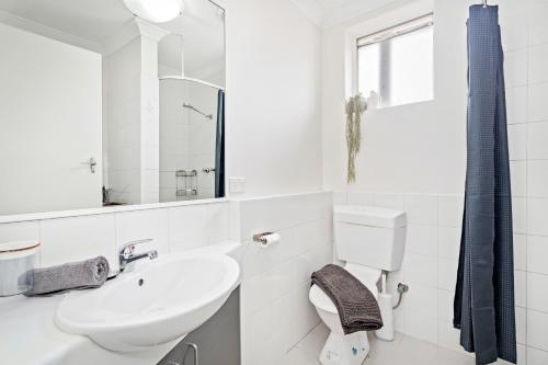 Baño blanco con lavabo y aseo en 8 Cute Cunningham Close To Subiaco - Sleeps 4, en Perth