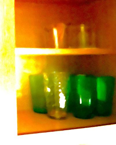 a shelf with green glass dishes on it at Disney 1 mile , Blue Heron 1 room 2 bath,amenities,6 guests, walk to restaurants, no fees at check in in Orlando