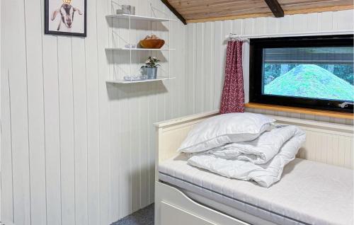 Awesome Home In Annerstad With Sauna في Annerstad: سرير صغير في غرفة صغيرة مع تلفزيون