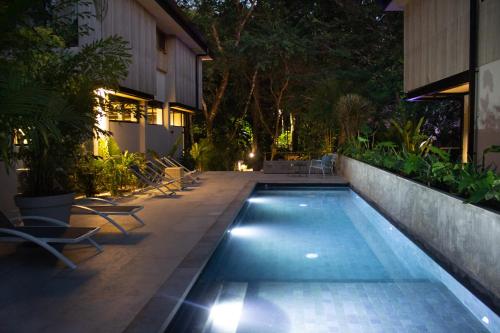 a swimming pool in the middle of a yard at night at D'Palm Villas in Puntarenas