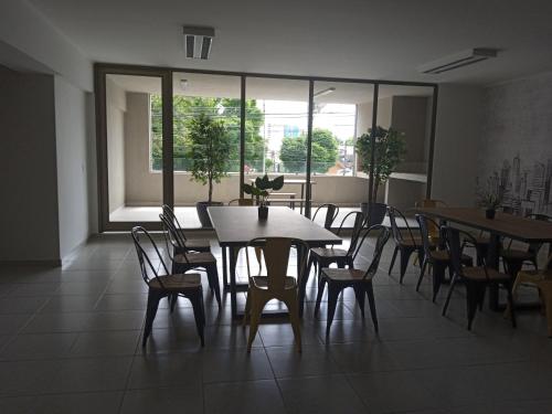 a dining room with tables and chairs and windows at DEPARTAMENTO ARAUCO CENTRO CHILLAN Con ESTACIONAMIENTO in Chillán