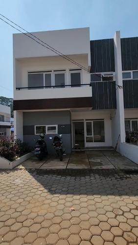 a house with two motorcycles parked in front of it at Disewakan Rumah minimalis 2 lantai Prestige 2 Sawangan in Depok