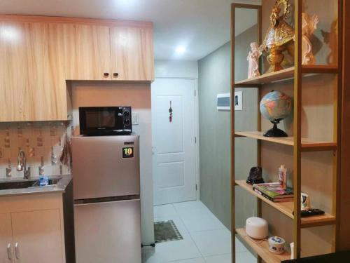 a kitchen with a refrigerator and a microwave at Naga City Stylish Condo in Naga