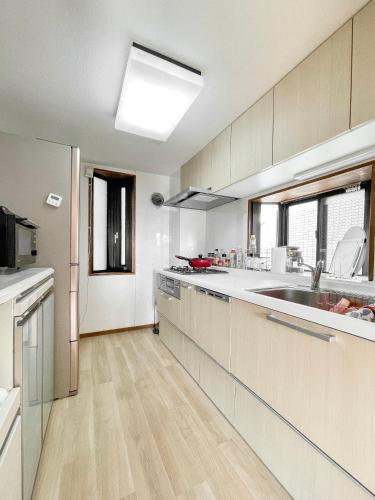 a large kitchen with a sink and a counter at 池袋新宿涩谷三地埼京线9分至16分直达 可住2人至10人 星の園 in Tokyo
