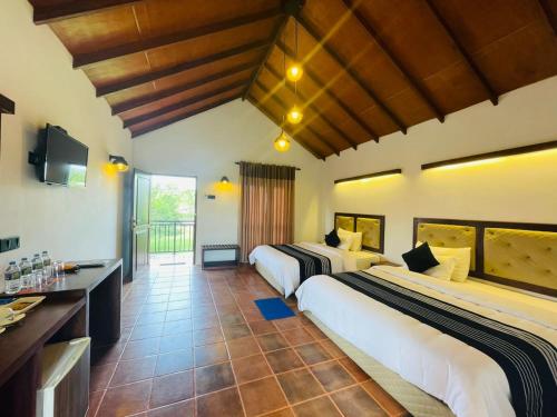 a hotel room with two beds and a television at Four Points Resort - Anuradhapura in Anuradhapura