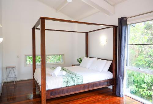 a bedroom with a canopy bed with white sheets at The Treehouse in Airlie Beach