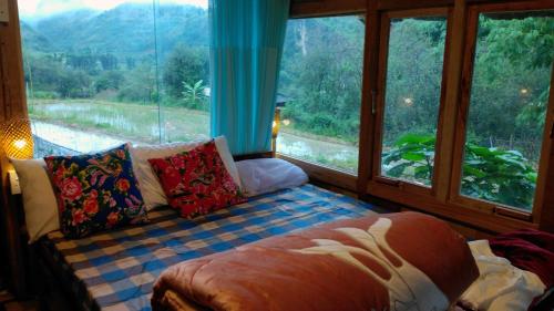 a living room with a couch and a large window at Ngoc Chien Pearl in Ngọc Chiến