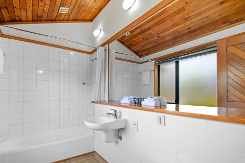 baño con lavabo, bañera y ventana en Riverside Hotel Marlborough en Blenheim