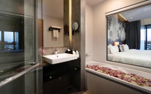 a bathroom with a sink and a bathroom with a bed at Koulen Central Hotel in Siem Reap