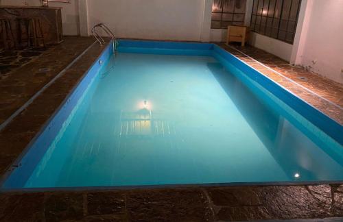 a large blue swimming pool in a building at Casa de Campo Buganvilllas in Mecapaca