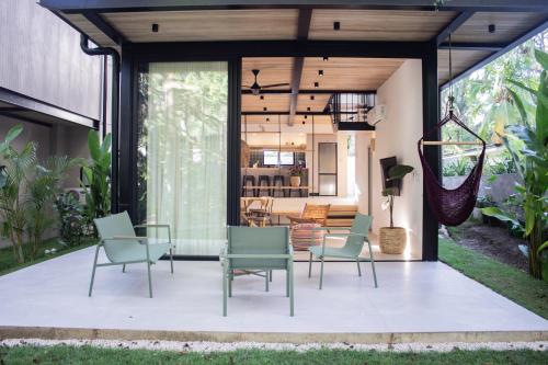 a patio with chairs and a dining room at D'Palm Villas in Puntarenas