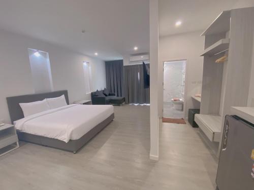 a bedroom with a white bed and a bathroom at GRAND PA Hotel&Resort Lamphun Chiang Mai in Lamphun