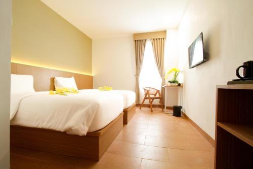 Habitación de hotel con 2 camas y ventana en Sepanak Hotel by Amazing en Curup